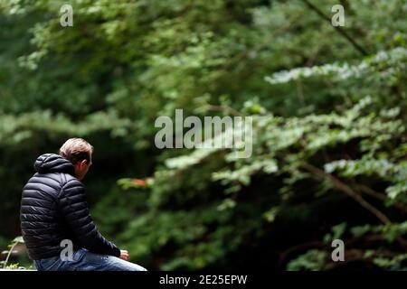 Giovane uomo che prega da solo in natura. Francia. Foto Stock