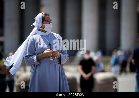 Una suora che pregava il santo rosario prima che il Papa Francesco viveva la preghiera dell'Angelus in piazza San Pietro il 24 maggio 2020 in Vaticano. Foto Stock