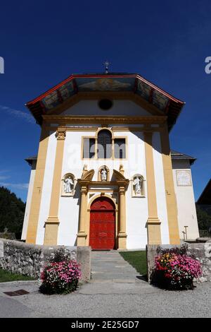 Fiori colorati nel villaggio di Saint Nicolas de Veroce nelle Alpi francesi. La chiesa barocca. Francia. Foto Stock