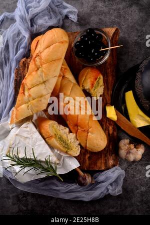 Baguette all'aglio bread. Aglio e burro di erbe su sfondo scuro Foto Stock