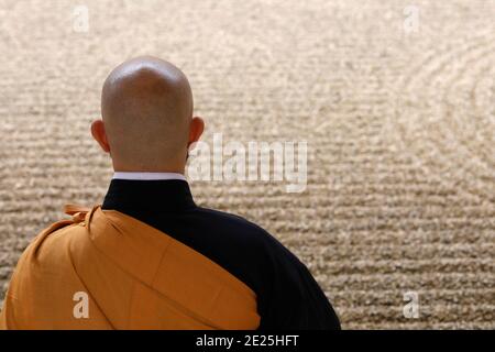 Zen maestro buddista che pratica zazen (meditazione) nel giardino zen dell'abbazia di Orval trappist, in Belgio. Foto Stock