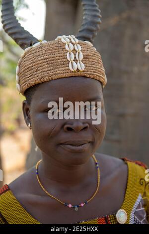 Giovane donna Batammariba con scarlatura che indossa un cappello tradizionale. Togo Foto Stock