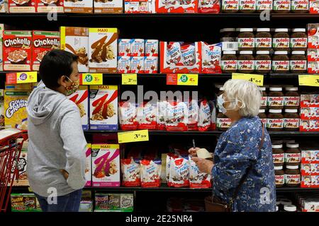 Ragazzo che acquista con la nonna in un supermercato durante la pandemia. Eure, Francia. Foto Stock