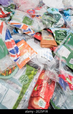 Pile massaggiate di sacchetti di plastica morbida per alimenti e materiale di imballaggio dai supermercati britannici. Per rifiuti da cucina, rifiuti di plastica per uso domestico, plastica monouso. Foto Stock