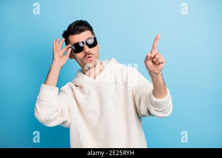Ritratto fotografico di un ragazzo fresco con gli occhiali a contatto con le setole rivolti verso l'altro dito sullo spazio vuoto isolato su sfondo di colore blu pastello Foto Stock