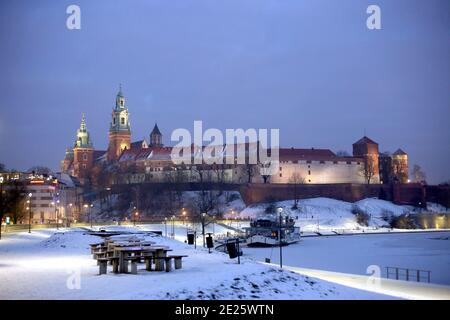 Cracovia. Cracovia. Polonia. Inverno notte wiev del castello reale di Wawel e la riva del fiume Vistola. Neve e fiume ghiacciato. Foto Stock