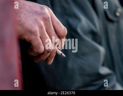 Uomo che fuma un roll-up alla partita di calcio Foto Stock