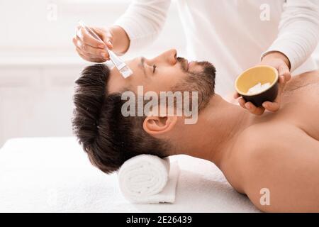 Bell'uomo di mezza età che ha un trattamento viso alla spa maschile Foto Stock