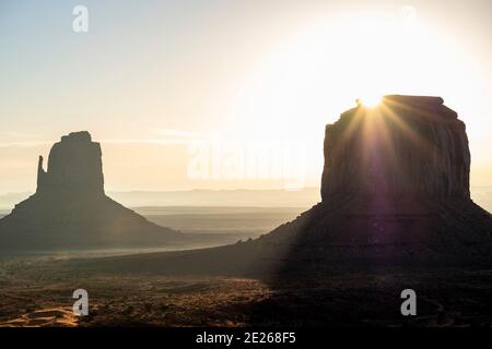 Vista iconica dell'alba sulle formazioni rocciose Merrick Butte e East Mitten in silhouette, Monument Valley Navajo Tribal Park, Arizona e Utah, USA Foto Stock