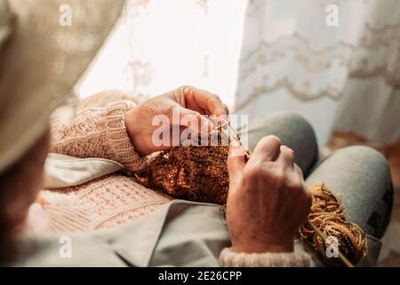 Primo piano di donne anziane tessitura mani. Periodo invernale. Vista dall'alto Foto Stock
