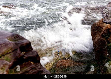 Una tempesta ha lavato via un gioiello alle rocce della costa del mare. Foto Stock