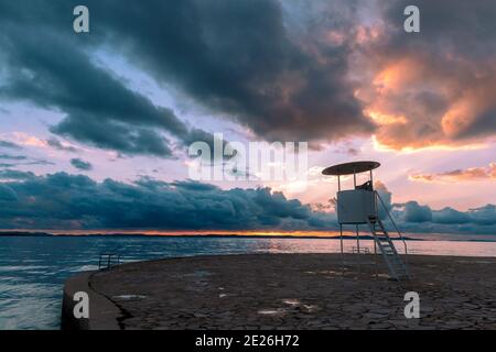 Bagnino torre di osservazione sulla spiaggia al tramonto, mare Adriatico, Croazia Foto Stock