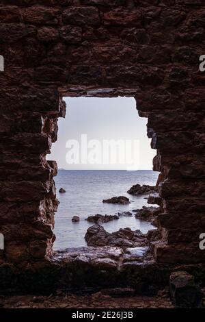 Vista sul mare attraverso le rovine di un'antica fortezza. Foto Stock