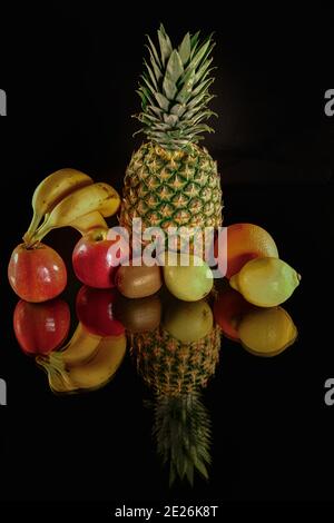 Colpo verticale di ananas con frutta matura fresca isolata uno sfondo nero Foto Stock