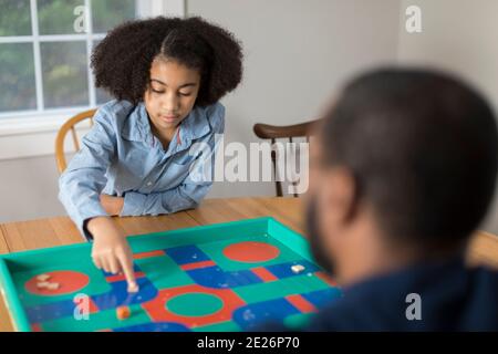 African America ragazza di dieci anni che gioca gioco da tavolo con il padre Foto Stock