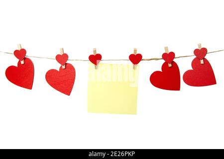 Nota appiccicosa bianca gialla appesa con cuori rossi isolati su sfondo bianco, concetto romantico di San Valentino, spazio copia Foto Stock
