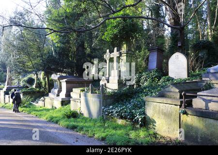 I memoriali unici e evocativi dell'Highgate Cemetery West, sulla Main Drive, sotto il sole invernale, nel nord di Londra, Regno Unito Foto Stock