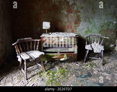 bellezza del decadimento - due sedie rotte e vecchio comò in una casa abbandonata, il tempo passa Foto Stock