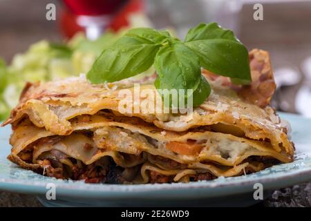 lasagna con insalata su legno scuro Foto Stock