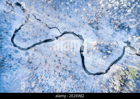 Fiume nella foresta invernale al tramonto, vista aerea Foto Stock