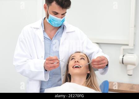 Donna in clinica stomatologica con dentista maschile. Denti sani, concetto di cura dentale. Foto Stock
