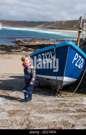 Little boy e una barca da pesca sullo scivolo di Sennen Cove, Penwith Peninsula, Cornovaglia, Regno Unito. MODELLO RILASCIATO Foto Stock