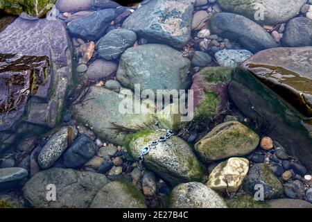 Una tempesta ha lavato via un gioiello alle rocce della costa del mare. Foto Stock