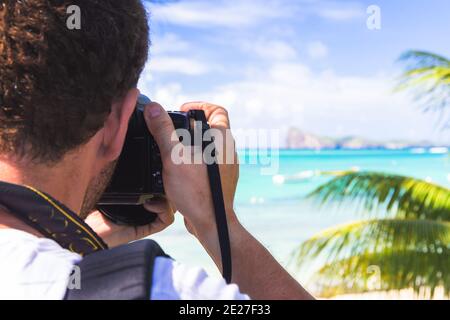 Uomo che tiene la macchina fotografica che scatta foto del paesaggio bello con oceano Foto Stock