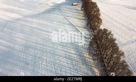 Drone aereo colpo di viale in inverno con piste e. ombre nella neve Foto Stock