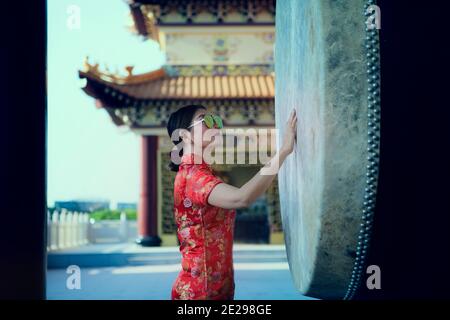 bella donna asiatica indossando vestito cinese rosso in piedi all'aperto Foto Stock