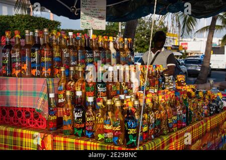 Guadalupa, Francia - 10 febbraio 2020: Mercato turistico tipico della Guadalupa che vende bevande tradizionali, spezie e altri prodotti. Foto Stock