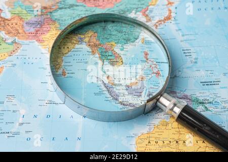 Bangkok, Thailandia - 01 agosto 2020 Asia, lente d'ingrandimento primo piano con la colorata mappa del mondo Foto Stock