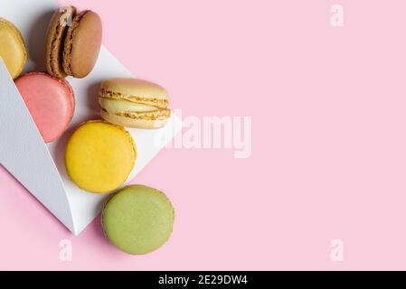 Macaron colorati come un regalo su sfondo rosa con copia spazio Foto Stock