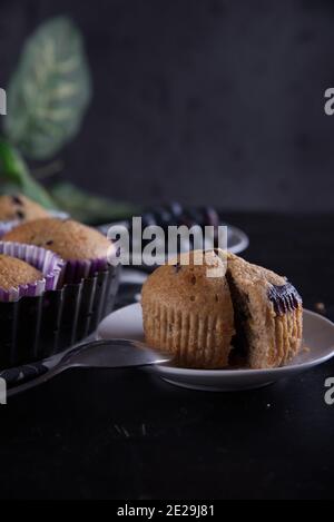 Focalizzazione selettiva dei muffin al mirtillo su un legno tagliere Foto Stock