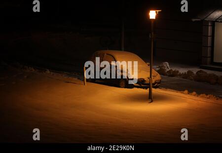 Marktoberdorf, Germania. 13 gennaio 2021. Un'auto innevata è parcheggiata di fronte a un edificio di appartamenti. Credit: Karl-Josef Hildenbrand/dpa/Alamy Live News Foto Stock