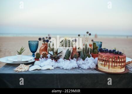 tavolo decorato per matrimoni con succulenti sulla sabbia Foto Stock
