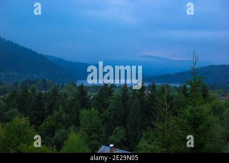 Paesaggio del Lago Bicaz circondato da montagne in serata Foto Stock