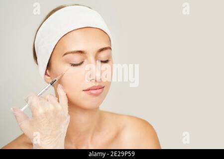 Cheek Injection spa salone. Mani del medico. Bella paziente femminile. Trattamento di bellezza Foto Stock