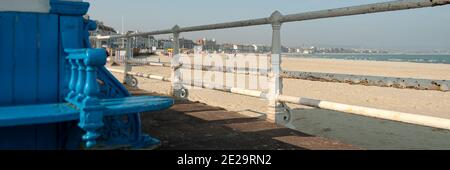 SWANAGE, DORSET, Regno Unito - 20 MARZO 2009: Vista panoramica della spiaggia centrale attraverso la ringhiera accanto al riparo spiaggia blu Foto Stock