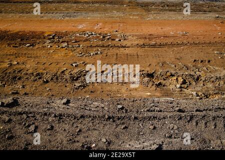 Vista del suolo marrone con i cingoli del veicolo sul massa Foto Stock