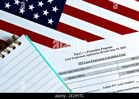 Primo piano del programma di protezione del pagamento modulo di richiesta di perdono del prestito revisionato topview, sullo sfondo della bandiera degli Stati Uniti. Protezione del pagamento Foto Stock