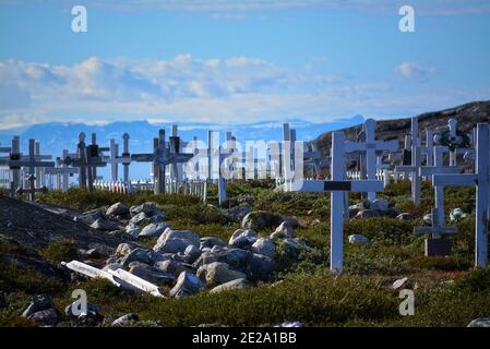 Groenlandia, Ilulissat, luglio - cimitero con croci nella tundra verde - cielo blu nella baia di Disko Foto Stock