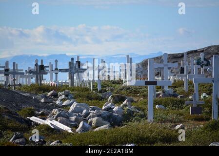 Groenlandia, Ilulissat, luglio - cimitero con croci nella tundra verde - cielo blu nella baia di Disko Foto Stock