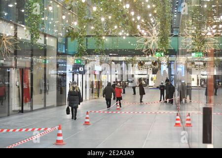 Di fronte ai negozi. 12 gennaio 2021. Foto a tema inverno nella pandemia del coronavirus. Lockdown prorogato fino al 31 gennaio 2021. Empty shopping Mall Fuenf Hoefe a Monaco il 12 gennaio 2021. Solo pochi passanti-by-pass negozi chiusi. Di fronte ai negozi si allungano le fasce flutter. | utilizzo in tutto il mondo credito: dpa/Alamy Live News Foto Stock