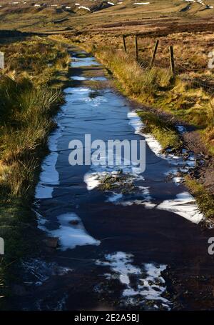 Surgelato puddle sul sentiero, Haworth Moor, Bronte Country Foto Stock