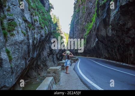 Vista posteriore della donna che tiene il cappello di paglia nel canyon di Bicaz Foto Stock