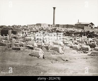 Fotografia d'epoca del XIX secolo: La colonna di Pompeo è il nome dato ad una colonna trionfale romana ad Alessandria d'Egitto. Fondata in onore del Diocleziano di augusto tra il 298-302 d.C., la colonna corinziana gigante originariamente supportava una colossale statua porfirica dell'imperatore in armatura. Immagine circa 1890 dello studio Bonfils mostra il cimitero circostante. Foto Stock