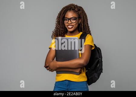 Istruzione del modello di serie - Friendly etnica donna nera studente di scuola superiore la digitazione sul computer portatile Foto Stock