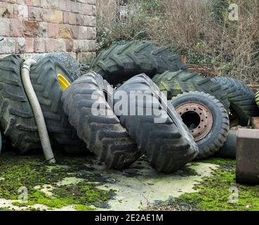 Collezione di pneumatici vecchi usurati in un'azienda agricola Foto Stock