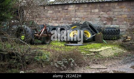 Collezione di pneumatici vecchi usurati in un'azienda agricola Foto Stock